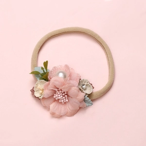 Detailed close-up of pink chiffon flower baby headband with pearls and rhinestones