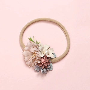 Detail of floral infant headband with pink mesh flowers and faux pearls on a nylon band