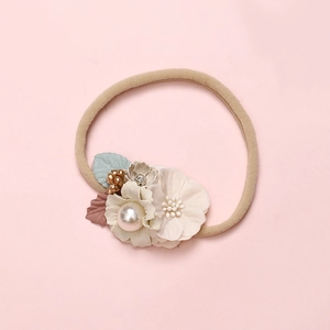 Detail of soft nylon infant headband featuring handmade fabric flowers and pearl accents