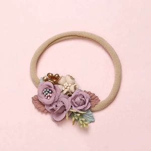 Detail of baby headband featuring soft fabric lavender roses and beige flowers on nylon