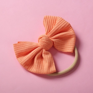 Détail macro du bandeau bébé en nylon corail côtelé avec nœud et élastique souple