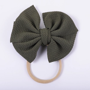 Detailed close-up of olive green waffle fabric bow on a soft elastic nylon headband