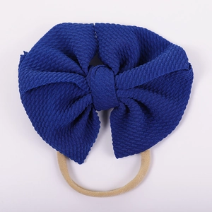 Detailed view of dark blue waffle fabric bow on a soft elastic nylon baby headband
