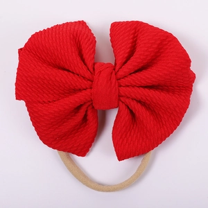 Detail of red waffle fabric baby headband with a large bow and high-elastic nylon loop
