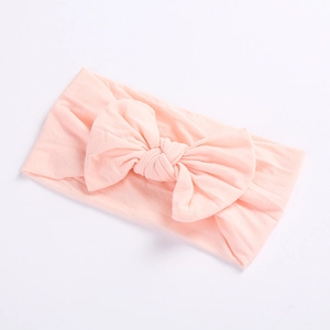 Zachte nylon baby hoofdband in lichtroze met een grote elastische strik voor kinderen