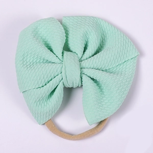Detailed view of mint green bubble fabric baby headband with a large textured bow