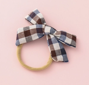 Detail of blue and brown checkered bow hair band with soft yellow elastic nylon strap