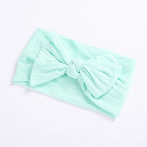 Zachte muntgroene nylon haarband voor baby's met een grote strik van rekbare stof