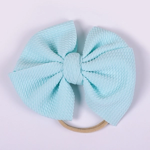 Detail of light blue waffle texture bow headband with highly elastic skin-tone band