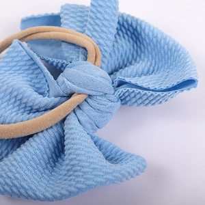 Light blue waffle textured double bow hairband with high elastic nude nylon band for babies