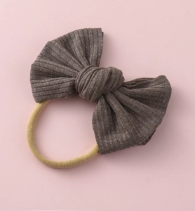 Détail du bandeau bébé avec nœud côtelé marron et bande élastique jaune en nylon