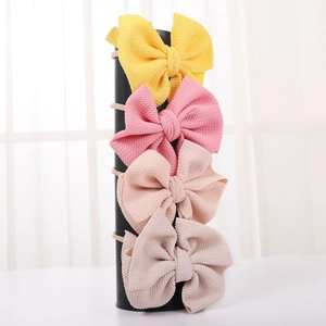 Detail of four-piece set waffle knit bow headbands for infants in assorted soft pastel colors