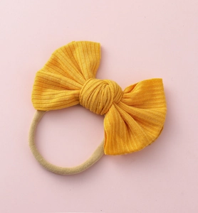 Détail du bandeau à nœud côtelé jaune vif avec bande en nylon extensible pour nourrissons
