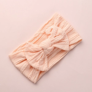 Soft cable knit nylon baby headband featuring a large bow in light peach pink color