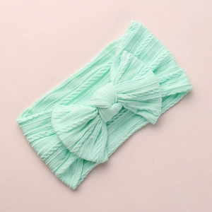 Mint green cable knit baby headband with oversized bow and soft elastic nylon fabric