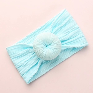 Light blue jacquard baby headband with donut knot on soft pink background