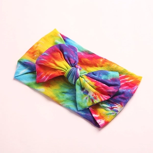 Détail d'un bandeau en nylon doux pour bébé avec un grand nœud coloré style tie-dye
