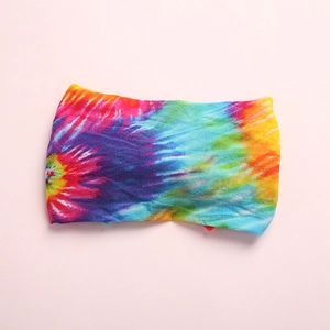 Vue détaillée du motif tie-dye sur un bandeau pour bébé en nylon doux et élastique