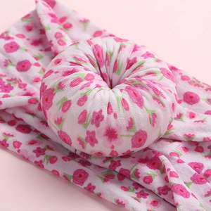 Soft nylon baby headband with pink floral print and a central donut knot decoration