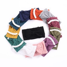 Detailed close-up of colorful baby nylon headbands with large bows and delicate lace trim