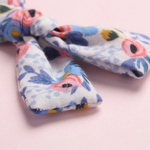 Blumige Haarschleife für Mädchen mit rosa und blauen Mustern auf weißem Baumwollstoff