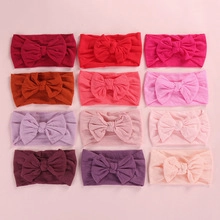 Detail view of twelve assorted colorful nylon flower headbands for babies and toddlers