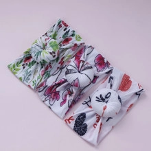 Detailed view of three baby nylon headbands with floral and heart patterns