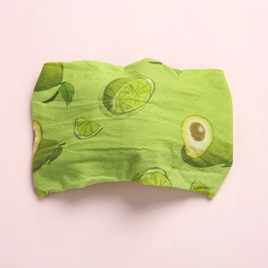 Close-up of bohemian style nylon baby headband with green avocado and lime fruit print