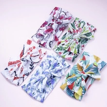 Close-up of 5-pack elastic baby headbands with assorted floral patterns and bow details