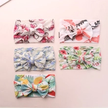 Close-up of five floral baby headbands with soft nylon bows and various colorful prints