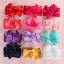 Flat lay of 12 multi-color grosgrain ribbon bow headbands for infants and toddlers