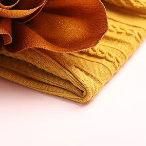 Close-up of mustard yellow cable knit nylon headband with a brown satin flower