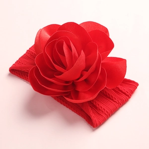 Detailed view of handmade red fabric flower on soft nylon knitted baby headband