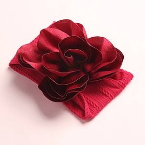 Detailed view of dark red soft nylon floral headband for infants with cable knit texture