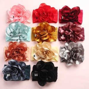 Vue détaillée de onze bandeaux en nylon souple pour bébés avec de grandes fleurs en tissu