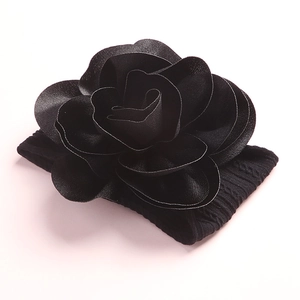 Close-up of a handmade black fabric 3D flower headband with soft nylon ribbed elastic base