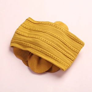 Bandeau bébé tricoté jaune gingembre avec motif torsadé et grande fleur décorative