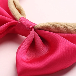 Rose pink satin bow headband for infants with a soft high-elastic beige nylon band