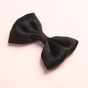 Close-up of the black satin bow hair clip showing smooth texture and elegant silk luster