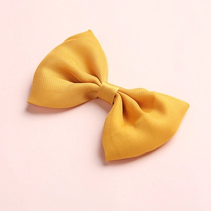Detailed close-up of bright yellow satin bow with fine diagonal texture and symmetric layers