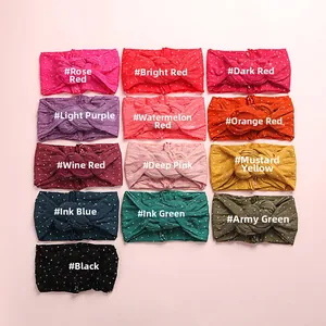 Vue à plat de 13 bandeaux bébé à pois colorés avec nœud torsadé en nylon doux