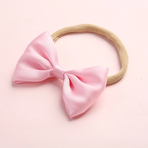 Close-up of pink satin bow baby headband with soft high-elastic nylon band