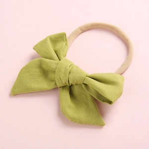 Detail of soft light green cotton bow headband with high-elastic nylon band for babies