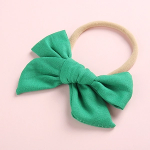 Close-up of green cotton bow hairband with high-elastic nylon strap for infants