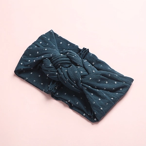 Détail du bandeau en nylon bleu foncé avec nœud et imprimé à pois argentés