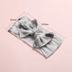 Detailed view of tie-dye nylon baby headband with bow, size 15x8.5cm on pink background