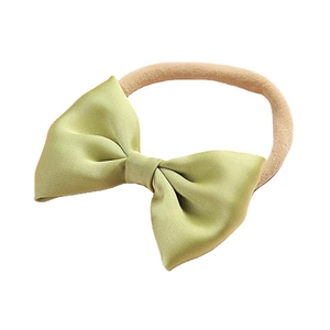 Elastic baby headband featuring a grass green satin bow on a soft nude nylon band