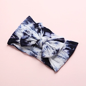 Detail of blue and white tie-dye baby headband featuring a large soft cotton bow