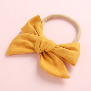 Detail of soft ginger yellow cotton bow headband with seamless elastic nylon band