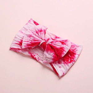 Pink and white tie-dye baby headband featuring a soft knit large bow knot design